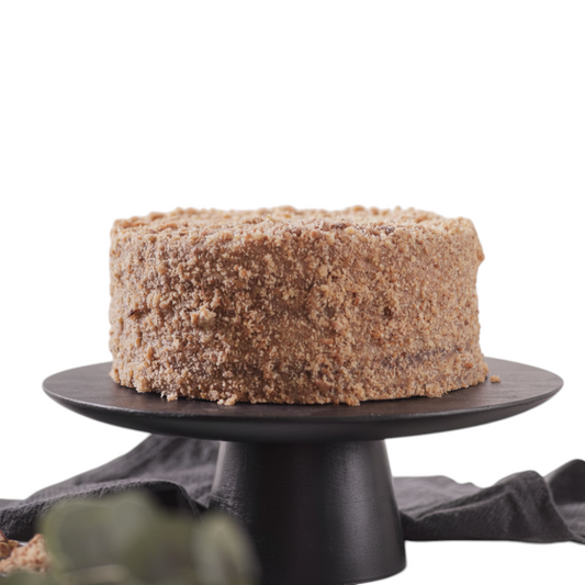 Maria Manjar Torta Crocante, a round cake with crunchy nut wafers and homemade dulce de leche filling, coated in crushed nuts.